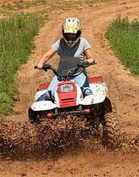 Someone riding an atv down a dirt hill.