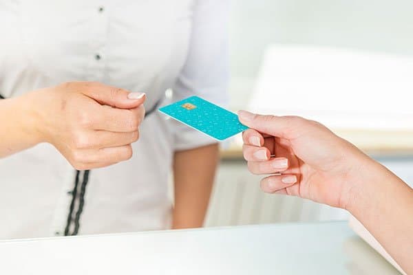 A woman using her credit card to pay for something.