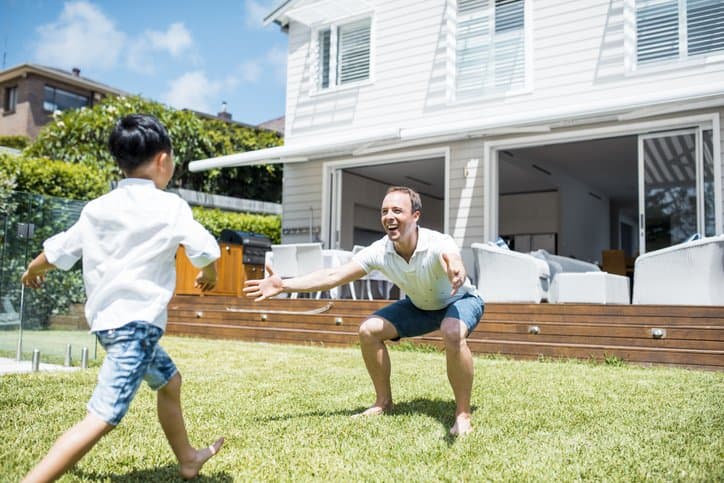 Father and son playing in the front yard of their home together.