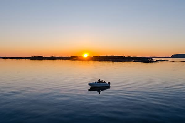Fisherman out on a boat at sunset.